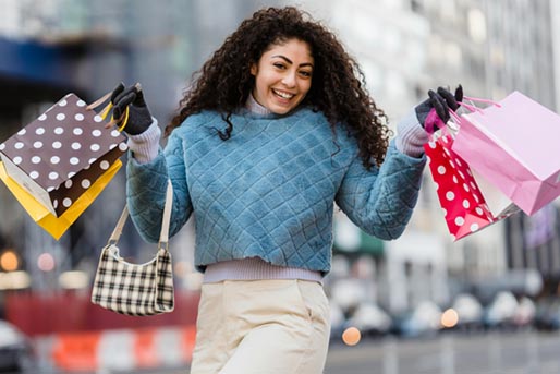 Young woman with gift bags. Photo by Tim Douglas : https://www.pexels.com/photo/delighted-young-woman-with-bright-gift-bags-after-shopping-6567285/